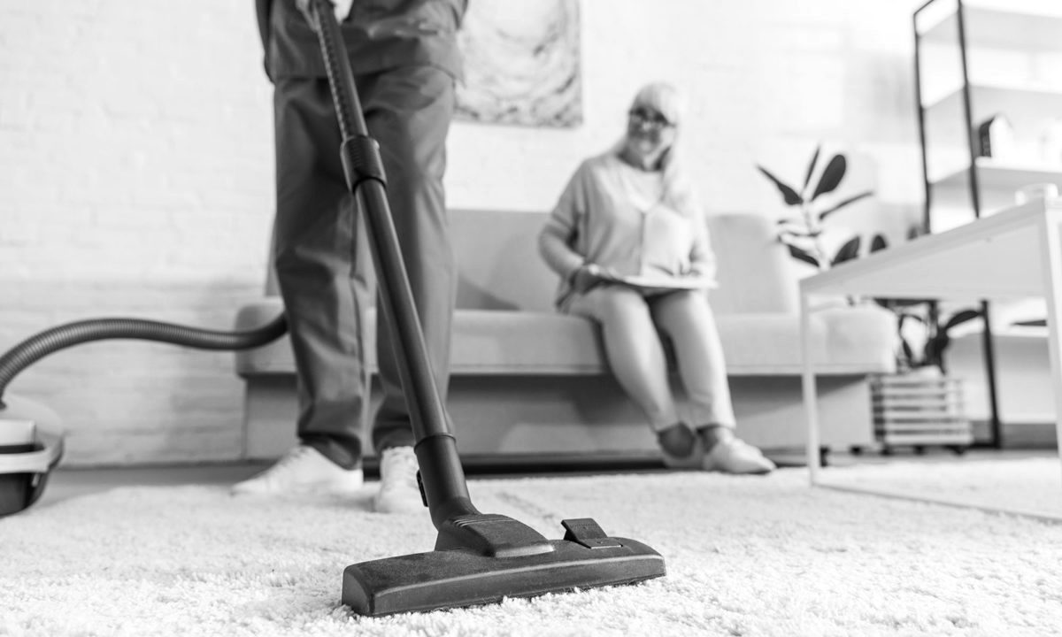 AllKlean cleaner vacuuming an aged care lounge