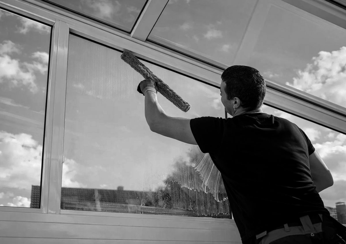 Window cleaner squeegeeing a large window